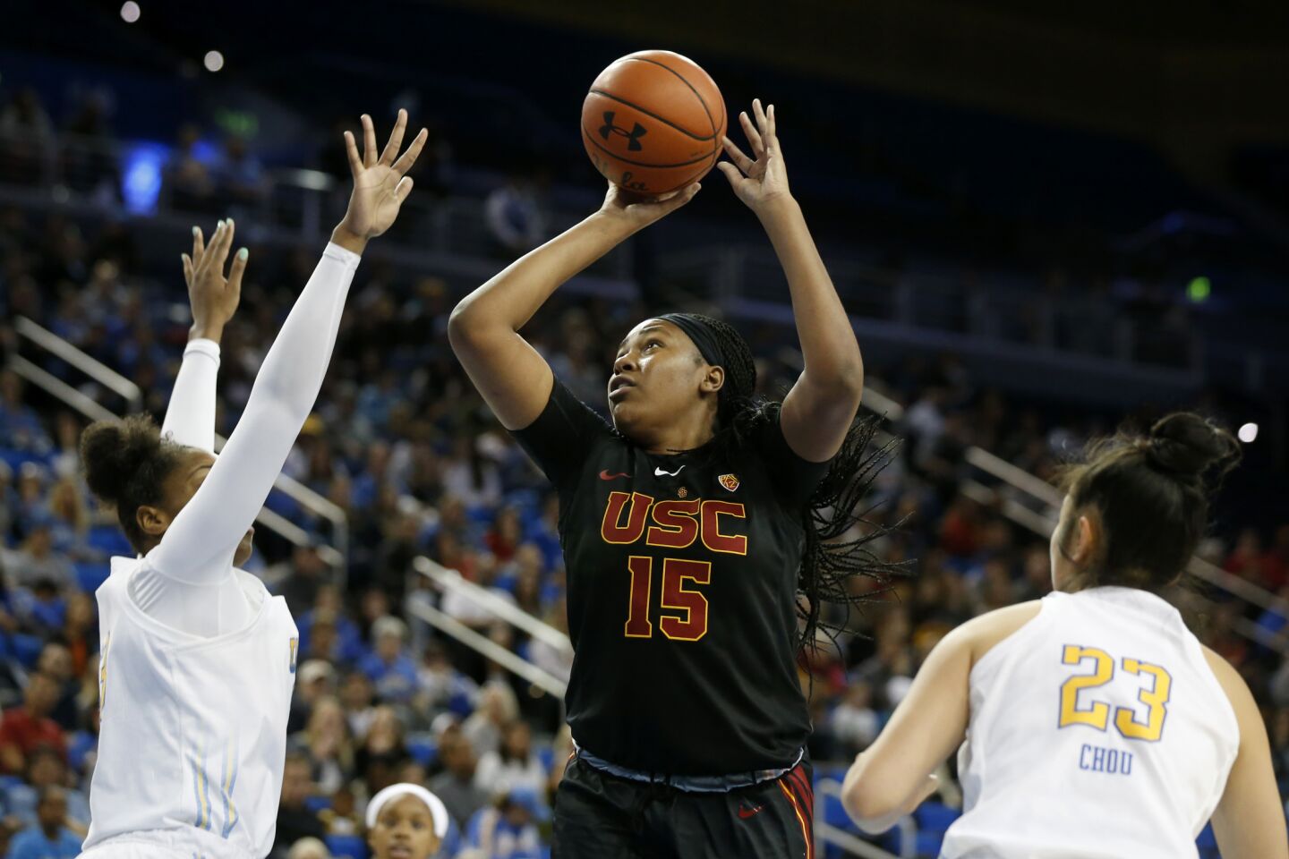 USC center Angel Jackson shoots between UCLA forward Lauryn Miller, left, and guard Natalie Chou (23) during the first half.