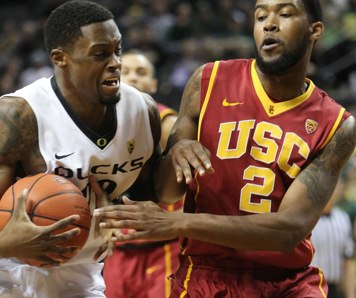 Oregon forward Elgin Cook battles for position against USC forward Malik Martin during the first half. The Trojans lost to the Ducks, 68-61.