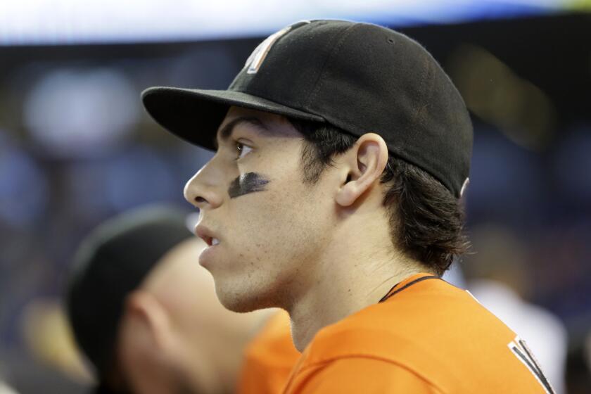 Miami Marlins left fielder Christian Yelich looks out from the dugout before a game against the Cincinnati Reds on July 12.