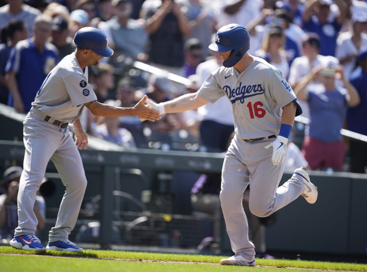 Dodgers third base coach Dino Ebel, left, congratulates Will Smith as he rounds the bases after hitting a two-run homer.