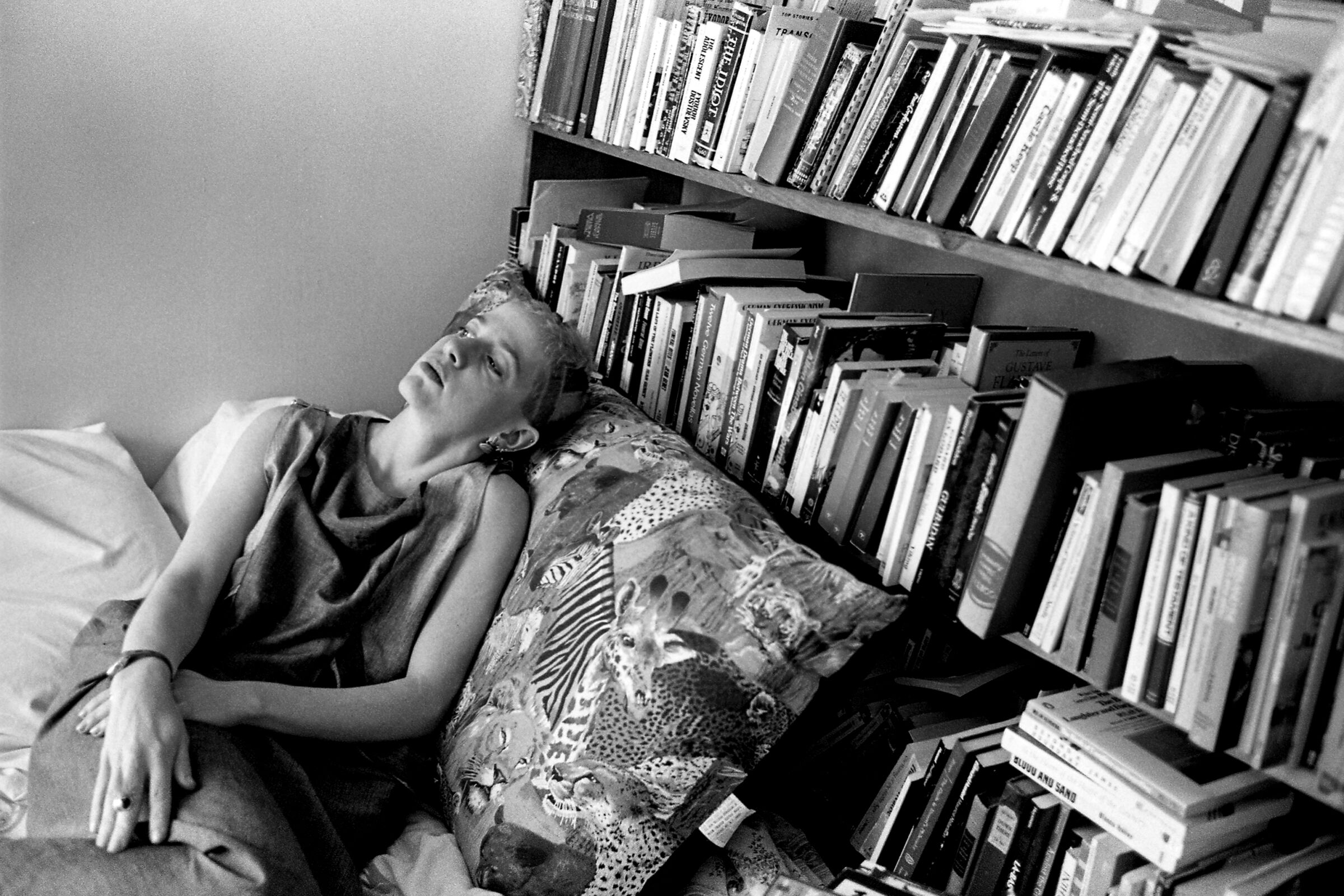 Kathy Acker, lying next to her library in her Lower East Side loft in 1983.
