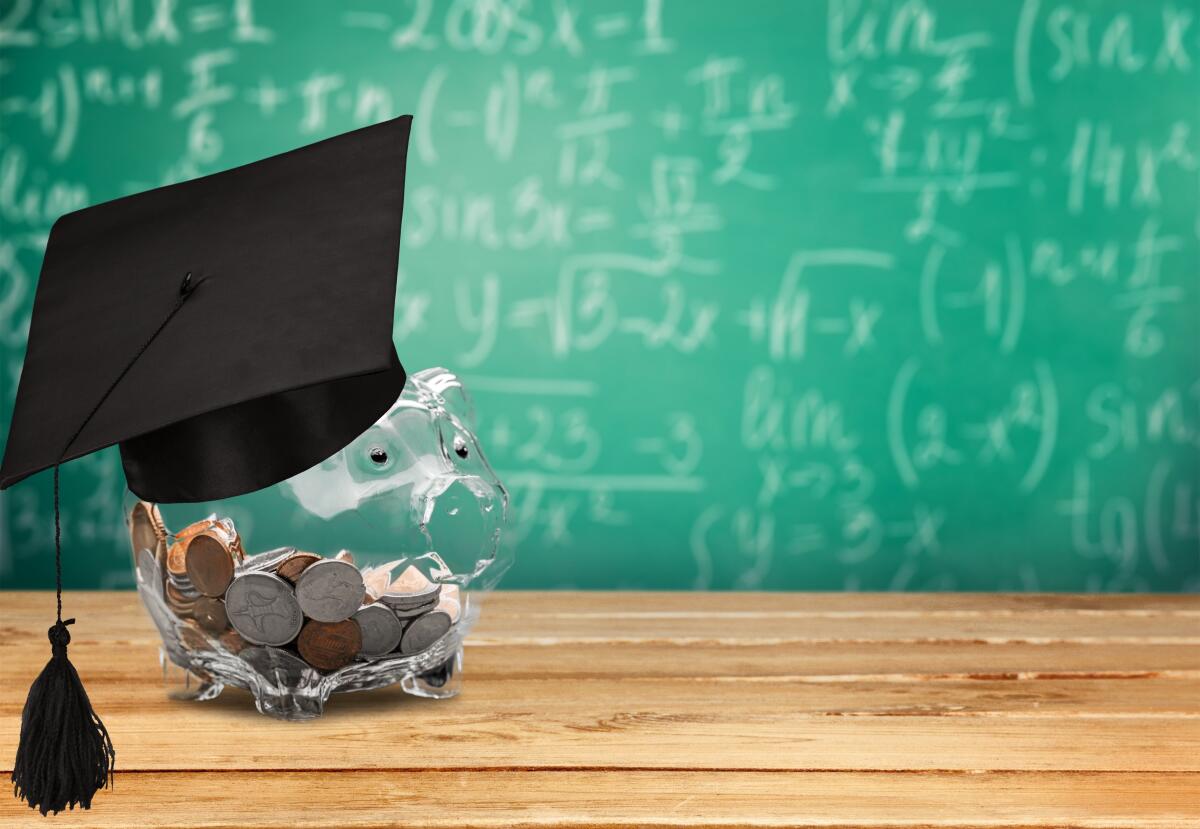 A school graduation cap sits atop a piggy banks. In the background is a chalkboard with equations.