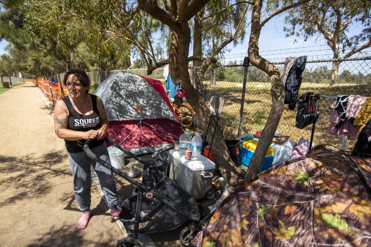 Deborah Edwards, 52, cleans up a site where she and three other homeless individuals have pitched tents.