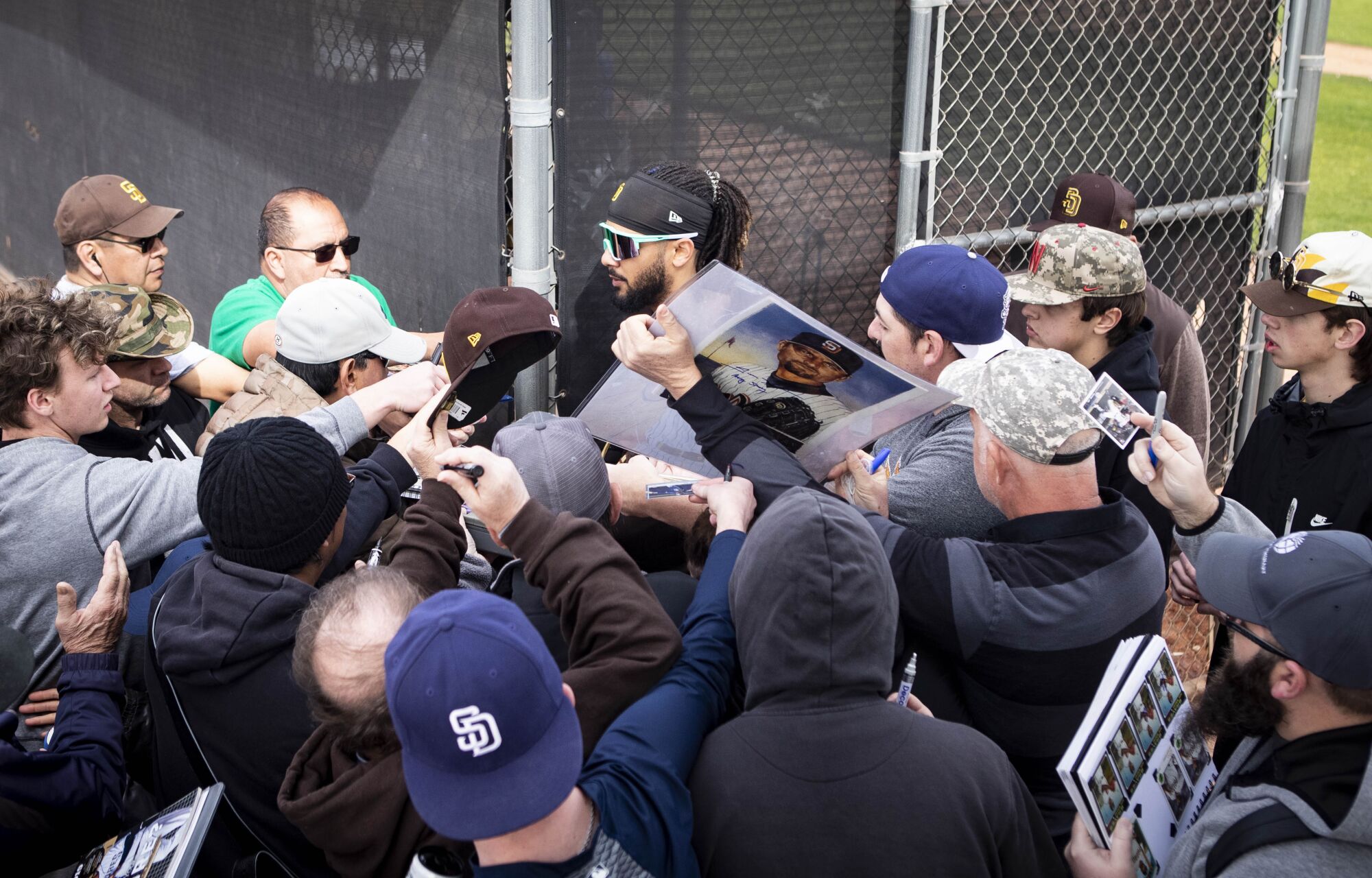 Padres infielder Fernando Tatis Jr., center, is swarmed by fans 