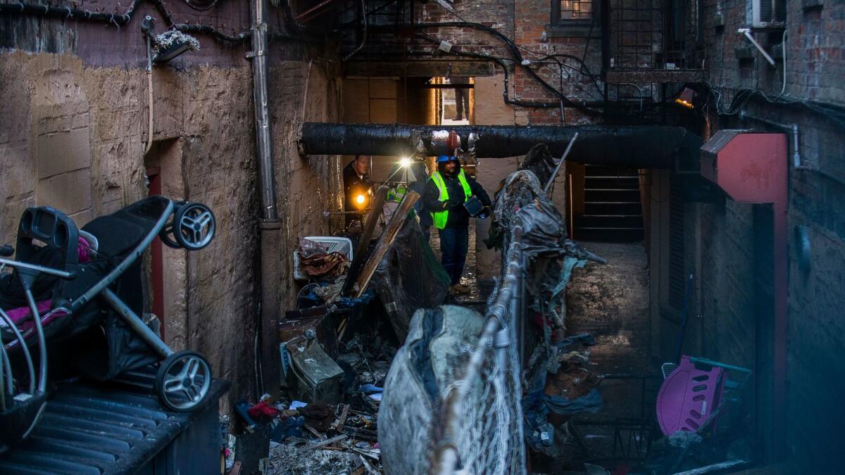 Police in the Bronx, N.Y., inspect the building where 12 people died in a fire.