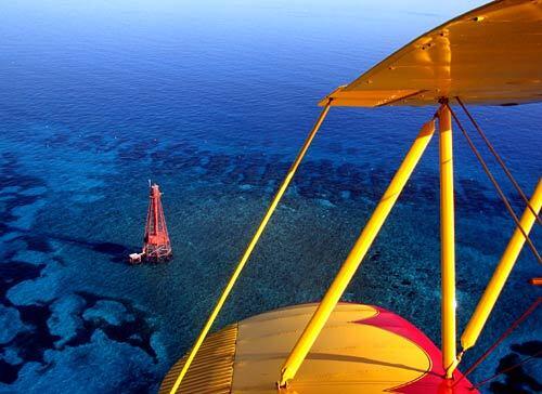 Paul Goodwin flies his bright yellow biplane over the Florida Keys. He believes that the plane and the ride, not the ocean, are what tourists remember most.