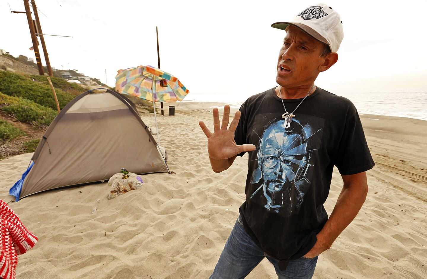 Michael Day, 46, sleeps along the sand of Will Rogers State Beach. He joins several other homeless individuals who are living in hidden encampments at the beach.