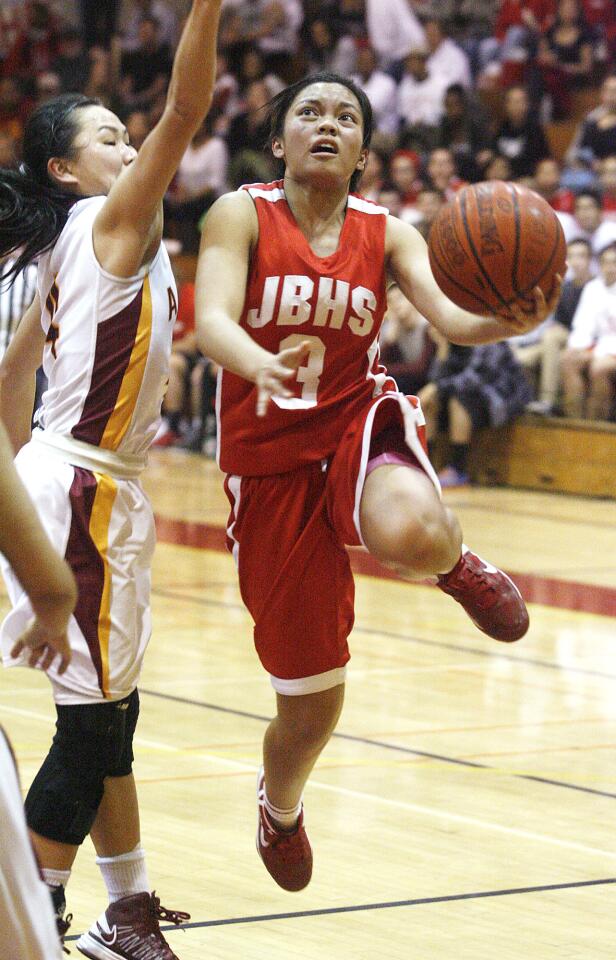 Burroughs' Sidney Ortega is fouled as she shoots to score a layup against Arcadia's Melody Chang in the second quarter in a Pacific League girls basketball game at Arcadia High School on Tuesday, February 5, 2013.