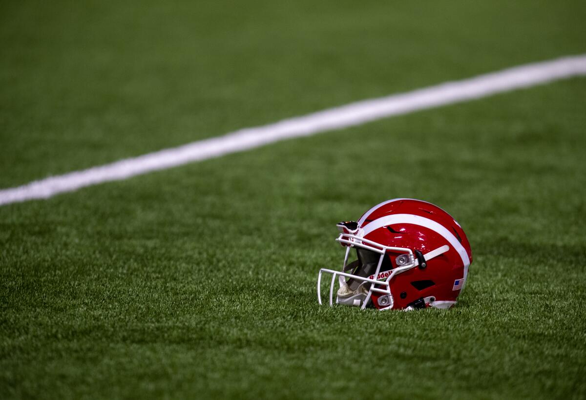A Mater Dei football helmet rests on the turf.