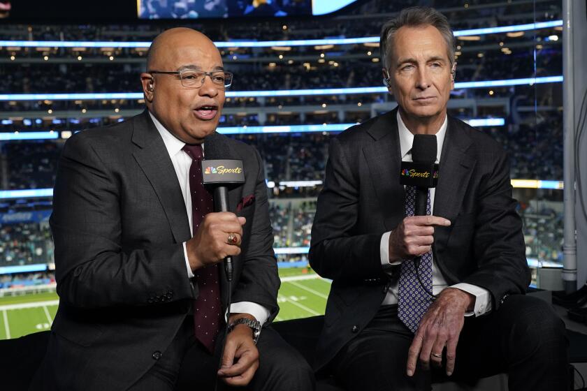 NBC Sports play-by-play announcer Mike Tirico, left, sits next to color commentator Cris Collinsworth 