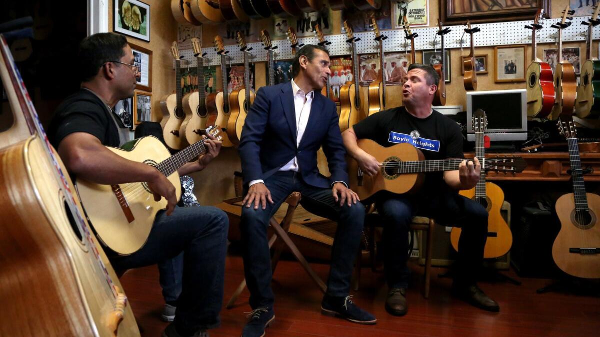 Antonio Villaraigosa, center, sings with Tomas Delgado, left, the owner of Candelas Guitars, and George Magallanes, as he campaigns in the Boyle Heights.