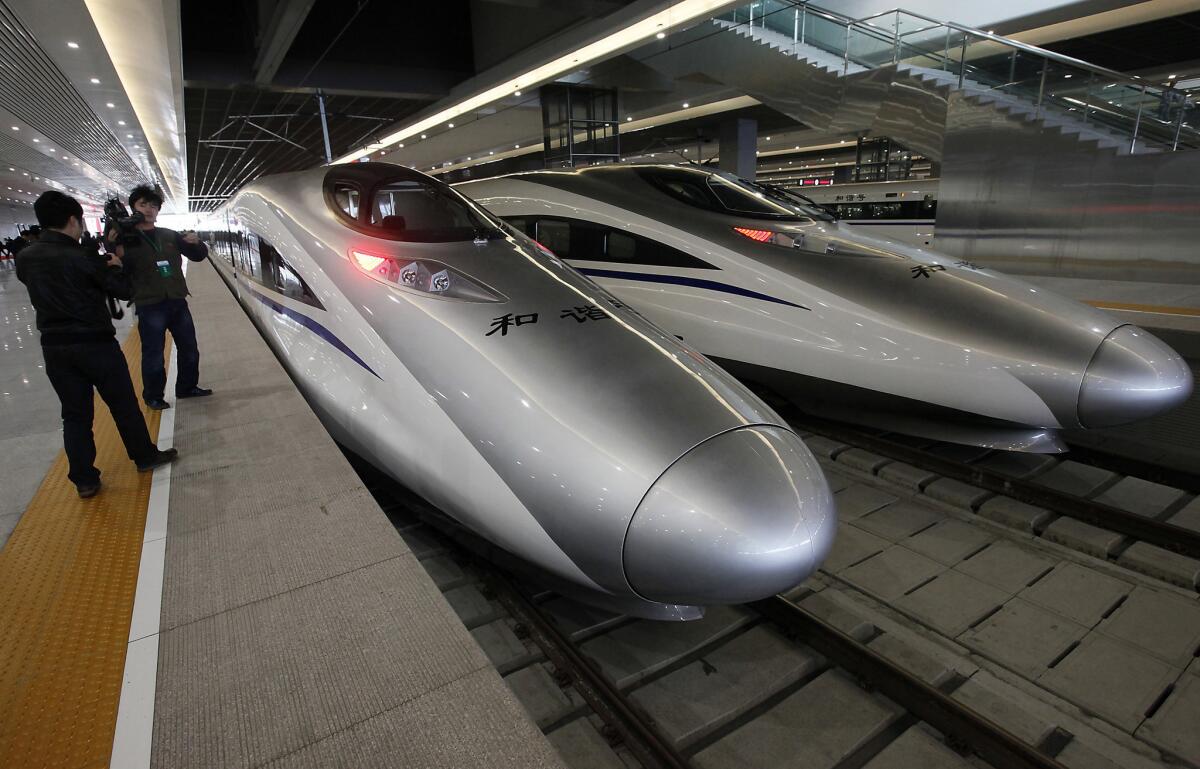 A journalist photographs bullet trains on a new high-speed railway linking Shanghai and Hangzhou in 2010.