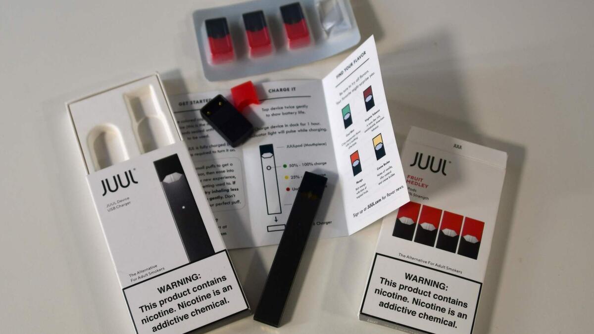 The contents of an Juul e-cigarette box, including vape pen and nicotine pods.