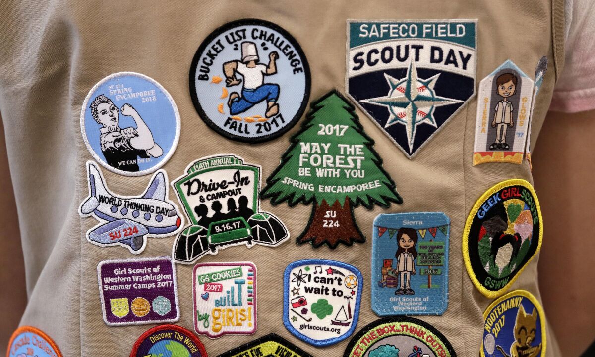 FILE - Patches cover the back of a Girl Scout's vest at a demonstration of some of their activities in Seattle, June 18, 2018. A federal judge, Thursday, April 7, 2022, tossed out a lawsuit in which the Girl Scouts claim that the Boy Scouts are creating marketplace confusion and damaging their recruitment efforts through their use of words such as "scouts" and "scouting." (AP Photo/Elaine Thompson, File)