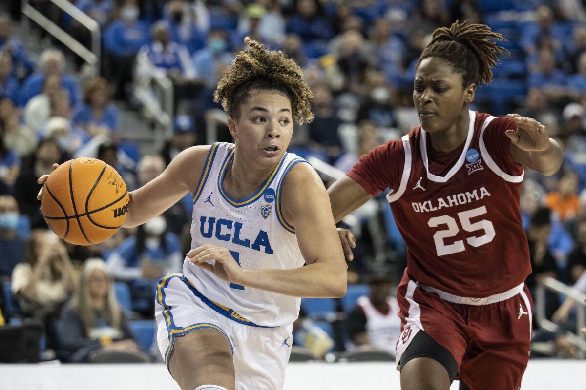 UCLA guard Kiki Rice drives toward the basket as Oklahoma forward Madi Williams defends.