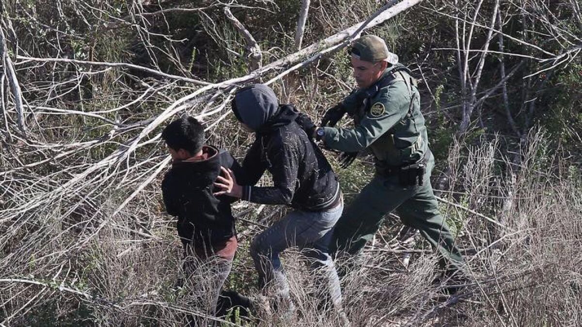 A Border Patrol agent detains undocumented juvenile immigrants in December.