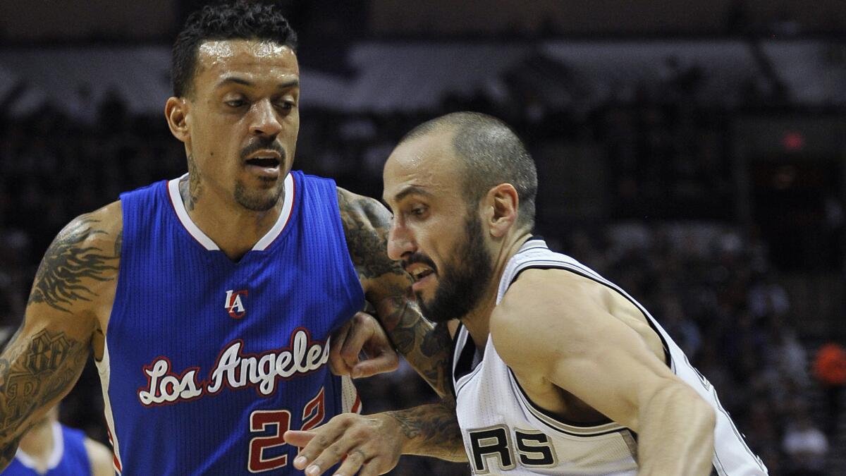 San Antonio Spurs guard Manu Ginobili, right, tries to drive past Clippers small forward Matt Barnes during the first half of a game on Dec. 22, 2014.