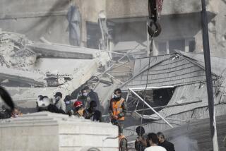 Emergency services work at a building hit by an air strike in Damascus, Syria, Saturday, Jan. 20, 2024. Syrian and Iranian state media outlets say an Israeli strike on t Damascus killed four Iranian advisers. (AP Photo/Omar Sanadiki)