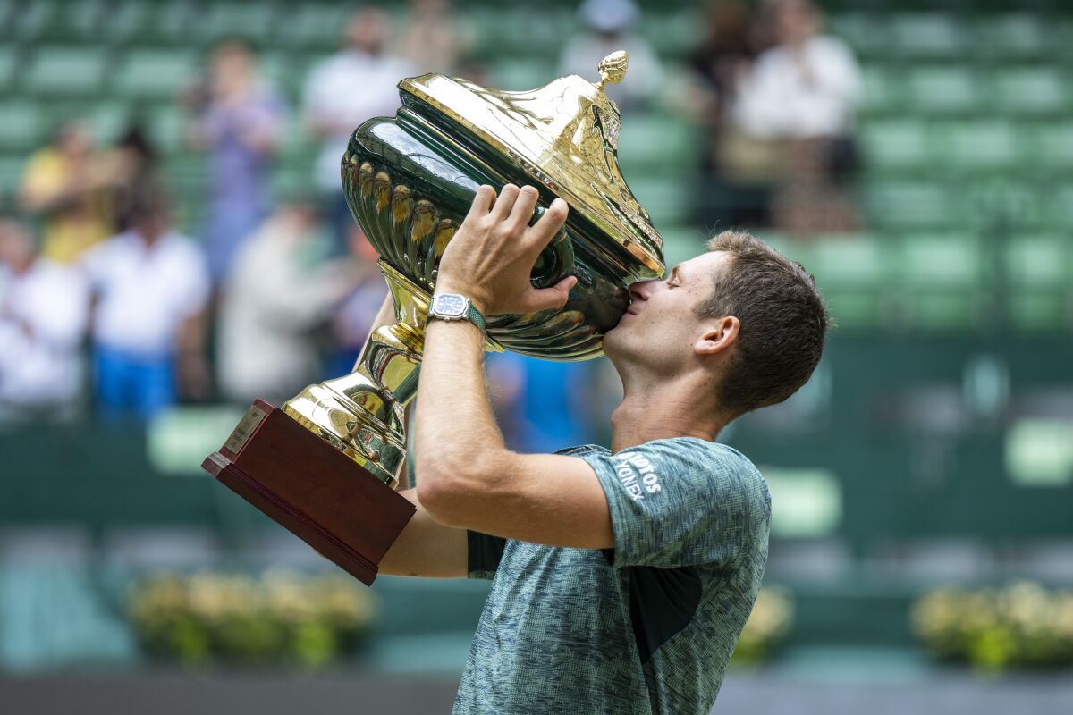 Poland's Hubert Hurkacz presents his winner's trophy after beating Russia Daniil Medvedev during the ATP Tour men's single final tennis match in Halle, Germany, Sunday, June 19, 2022. (David Inderlied/dpa via AP)