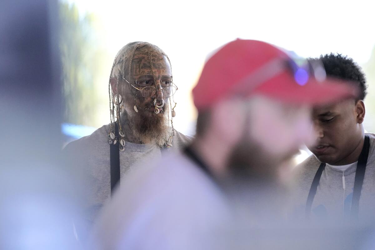 A man with face tattoos attends an event with other people