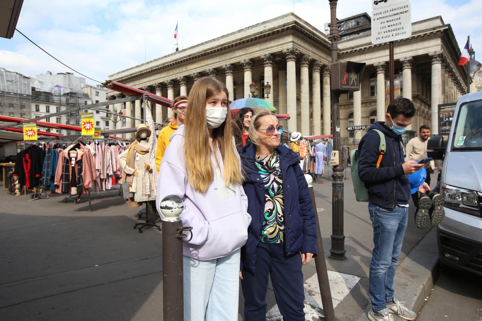 Yuliya Tkachenko, 45 and her daughter Nadiya Guidez, 15, walk outside a Metro subway stop in Paris