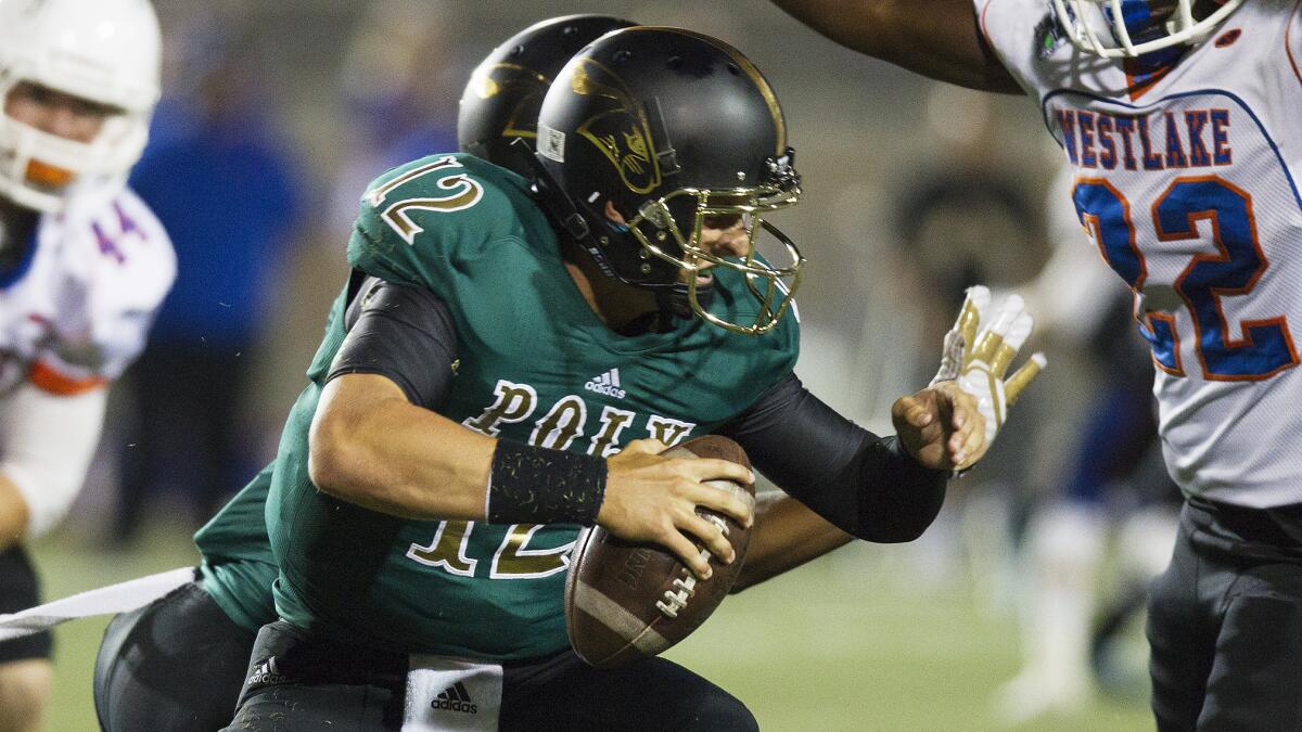 Long Beach Poly quarterback Josh Love tries to avoid a Westlake defender during a game on Sept. 12.