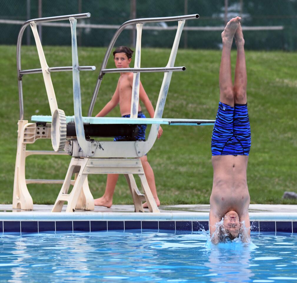 West Howard's Eliot Horwath, right, enters the water after a dive against North Saint Johns in youth diving competition.