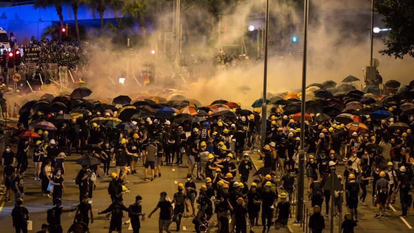 Police fire tear gas as they charge toward protesters in Hong Kong on Tuesday.