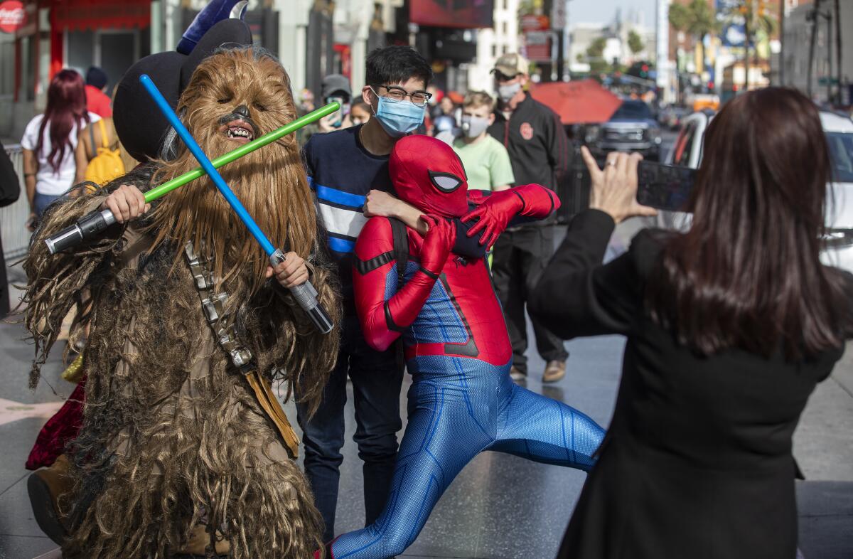 On Hollywood Boulevard, a costumed Chewbacca and Spider-Man interact with visitors. 
