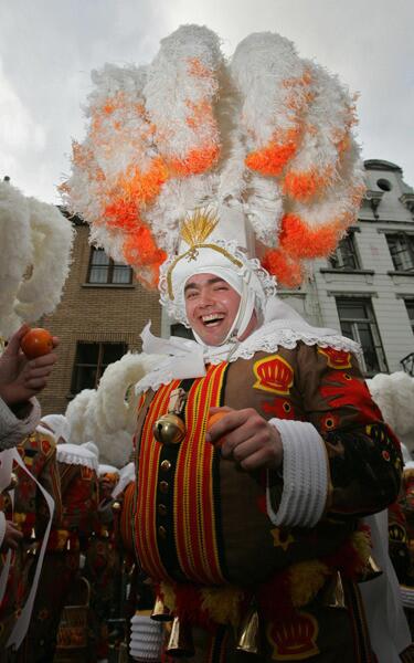 A man dressed as Gilles de Binche, smiles during a carnival parade in the streets of Binche on Mardi Gras.