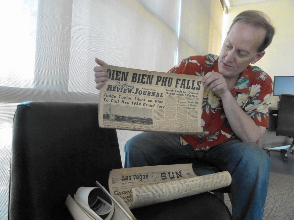 Dennis McBride, head of the Nevada State Museum, shows a newspaper from a 1954 time capsule.