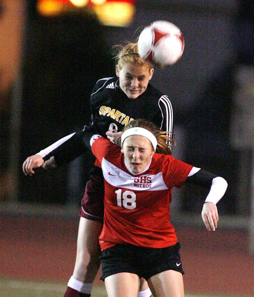 La Canada's Kara Lankey jumps over Glendale's Meghan Spencer to head the ball in the first half of a non league girls soccer match at Glendale High School on Monday, December 17, 2012.