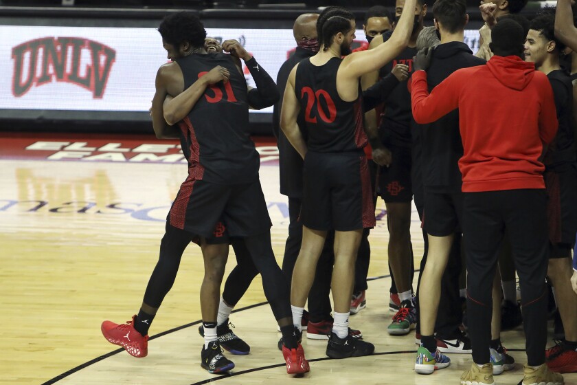 San Diego State's Nathan Mensah (31) and Adam Seiko (2) celebrate after defeating UNLV following an NCAA college basketball game Wednesday, March 3, 2021, in Las Vegas. (AP Photo/Joe Buglewicz)