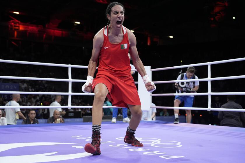 La argelina Imane Khelif celebra tras derrotar a la húngara Anna Hamori, en la categoría de 66 kilogramos del boxeo olímpico, el sábado 3 de agosto de 2024, en París (AP Foto/John Locher)
