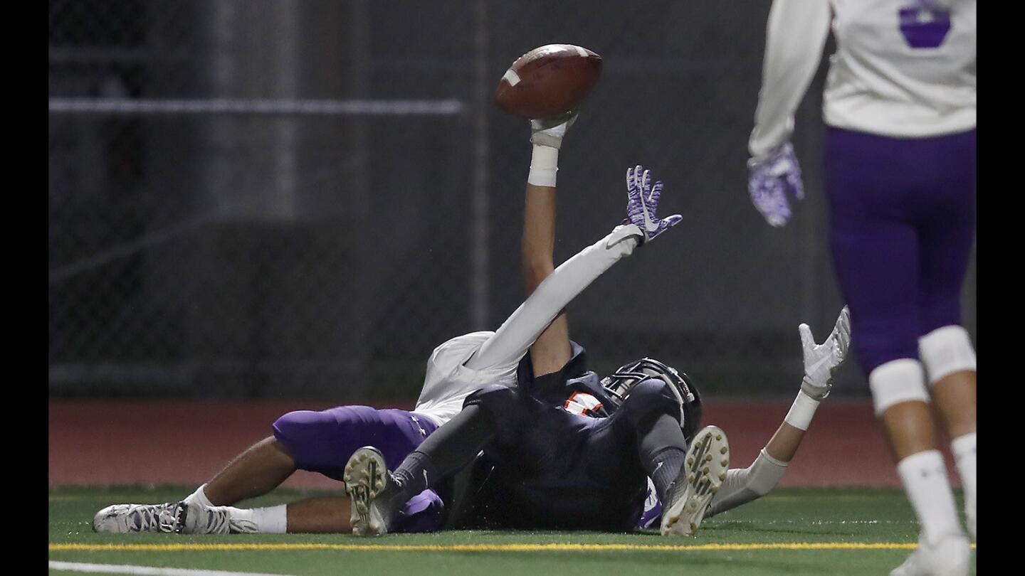 Los Amigos High's Christian Santana holds the ball up after completing a touchdown reception during the first half against Santiago in a Garden Grove League game at Garden Grove High School on Thursday, Oct. 26.