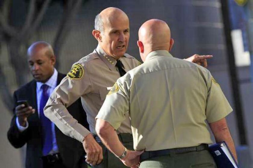 Sheriff Lee Baca, left, talks to captain Ralph Ornelas on arrival at Men's Central Jail on Saturday.