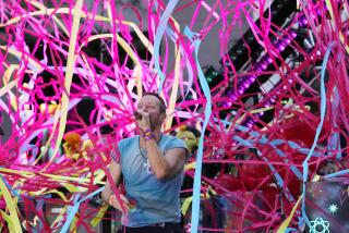 Chris Martin performs with Coldplay as multi-color streamers burst around him