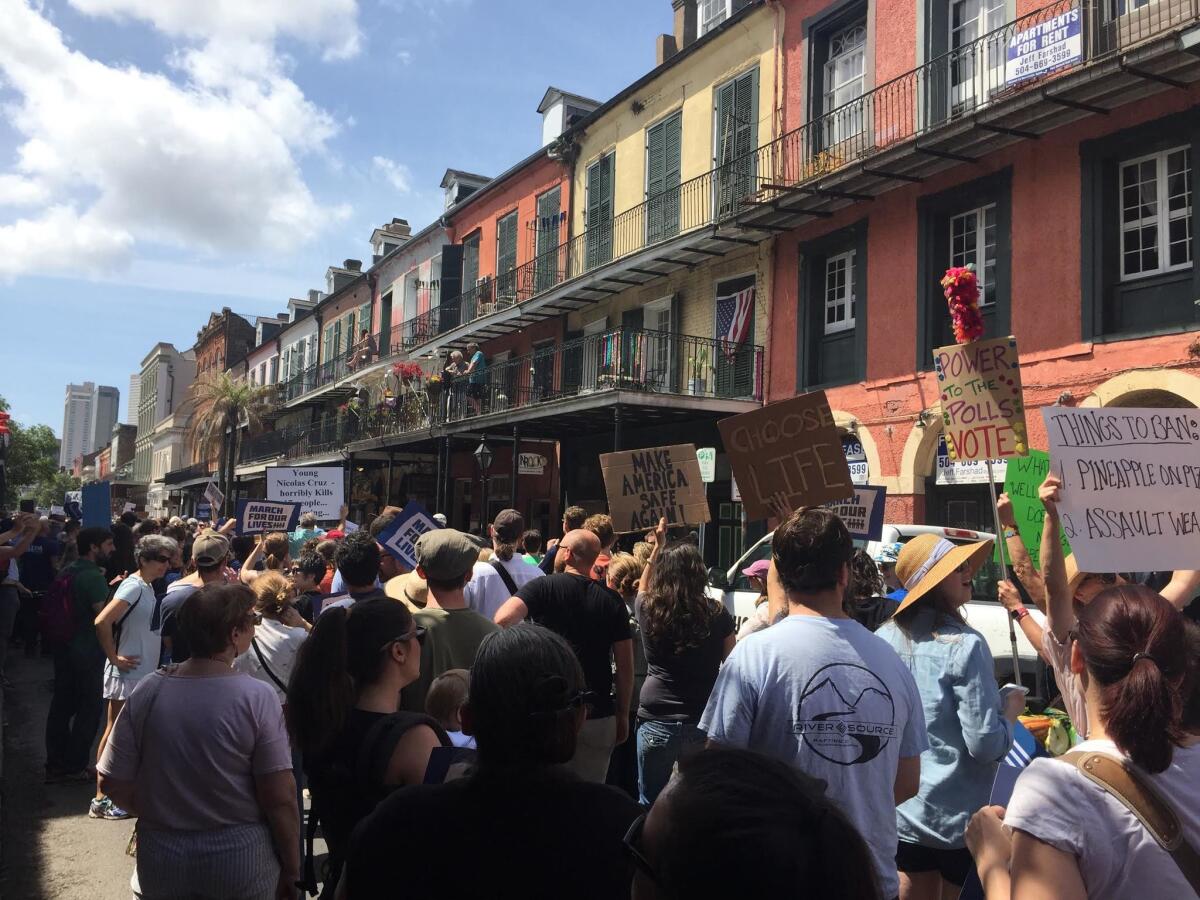 Marchers walk along Decatur Street in the French Quarter of New Orleans.