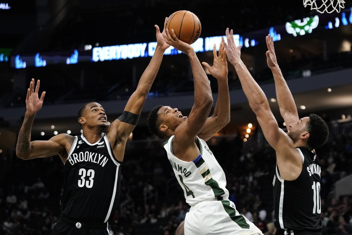 Brooklyn Nets' Nic Claxton (33) blocks a shot attempt by Milwaukee Bucks' Giannis Antetokounmpo (34) during the second half of an NBA preseason basketball game Wednesday, Oct. 12, 2022, in Milwaukee. (AP Photo/Aaron Gash)