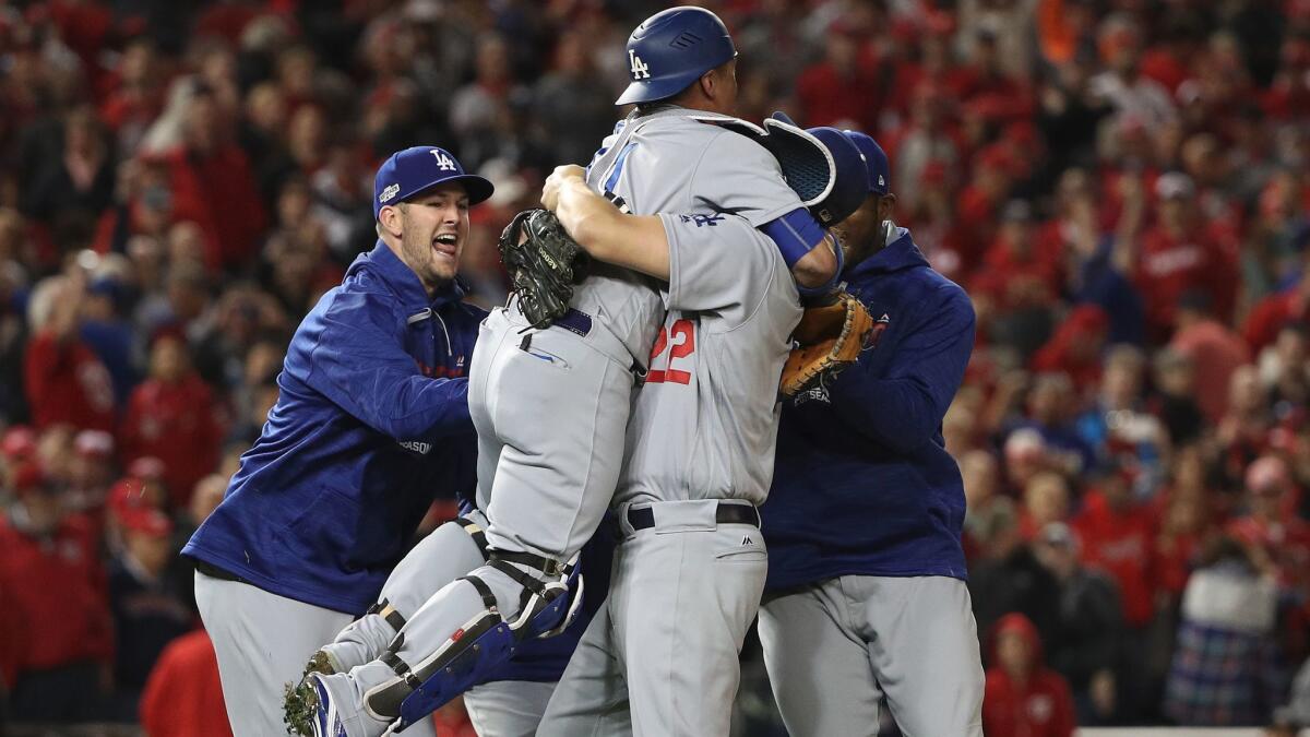 Catcher Carlos Ruiz leaps into the arms of pitcher Clayton Kershaw as the Dodgers start to celebrate their Game 5 win over Washington.