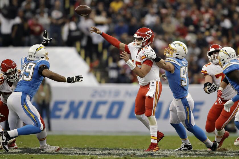 Kansas City Chiefs quarterback Patrick Mahomes throws a pass under pressure from Los Angeles Chargers defensive end Joey Bosa during the second half of an NFL football game Monday, Nov. 18, 2019, in Mexico City. (AP Photo/Marcio Jose Sanchez)