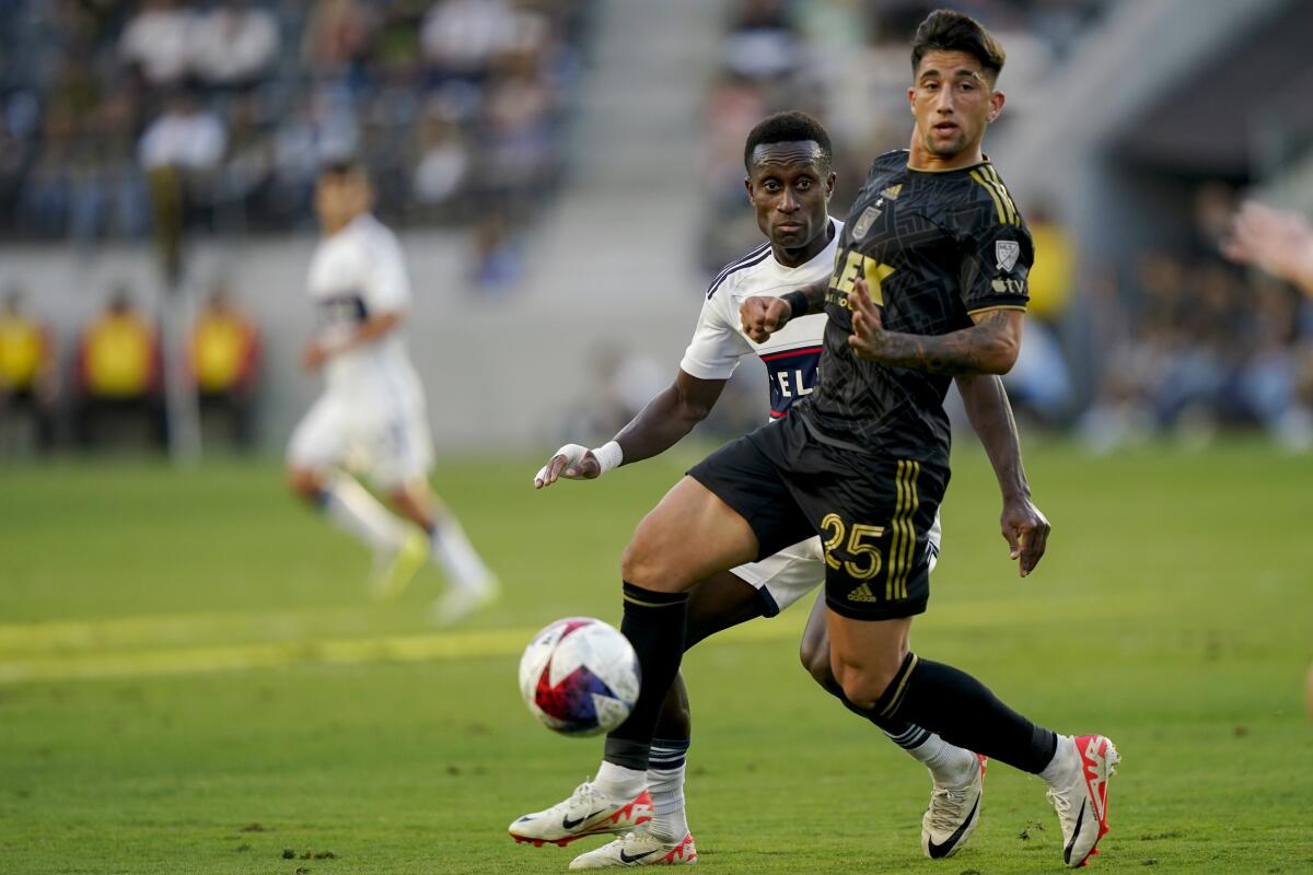 Vancouver midfielder Richie Laryea, rear, passes the ball in front of LAFC forward Cristian Olivera.