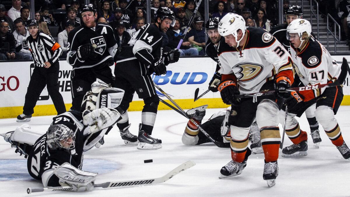 Kings goalie Jonathan Quick, left, makes a save on a shot by Matt Beleskey, right, during the second period of the Kings' 3-2 overtime win Saturday at Staples Center.