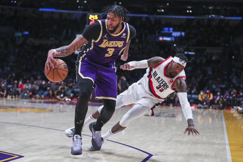 Los Angeles, CA - February 02: Los Angeles Lakers center Anthony Davis, left, battles for control of the ball against Portland Trail Blazers forward Robert Covington as he falls to the ground in the second half at Crypto.com Arena in Los Angeles Wednesday, Feb. 2, 2022. Lakers won 94-99. (Allen J. Schaben / Los Angeles Times)