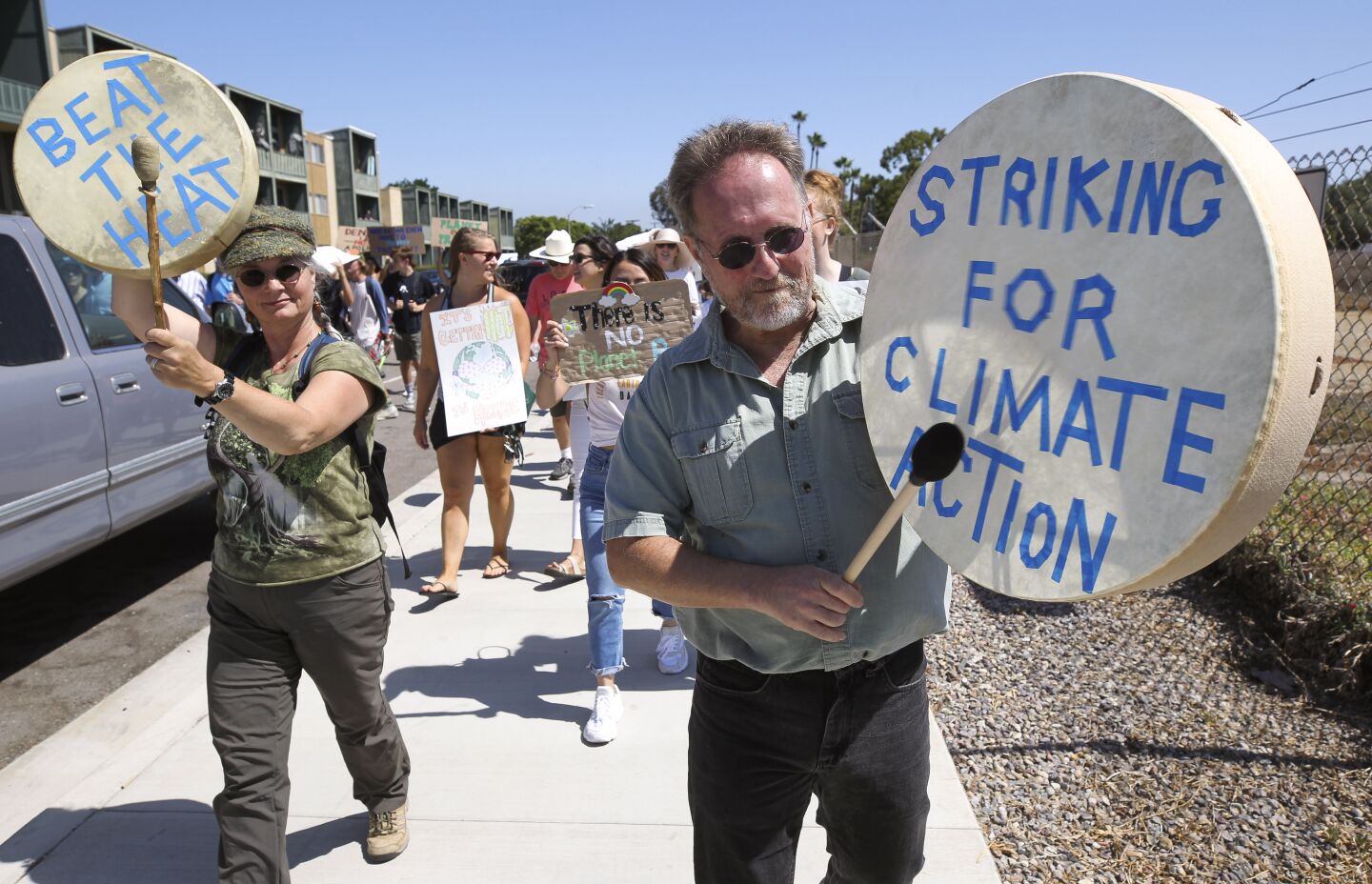 Jon and Sabine Sherman bang drums as they march with Mission Bay High School students participating in the Global Climate Strike in Pacific Beach on Friday, September 20, 2019 in San Diego, California.