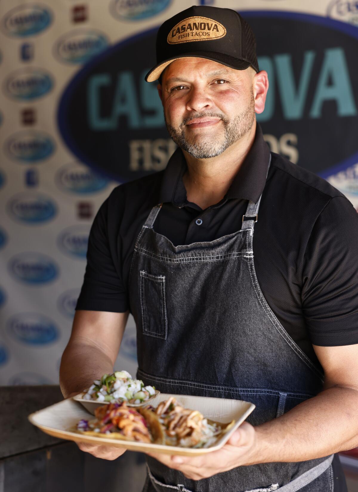 Hector Casanova of Casanova Fish Tacos displays a platter with three of his specialties.