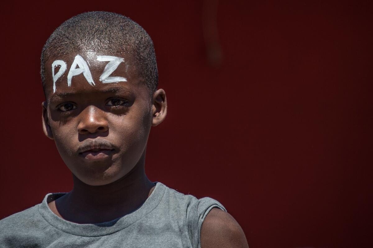A boy with the word "peace" on his forehead takes part in the march at Rio de Janeiro's Complexo do Alemao favela to protest the police shooting death of a 10-year-old boy.