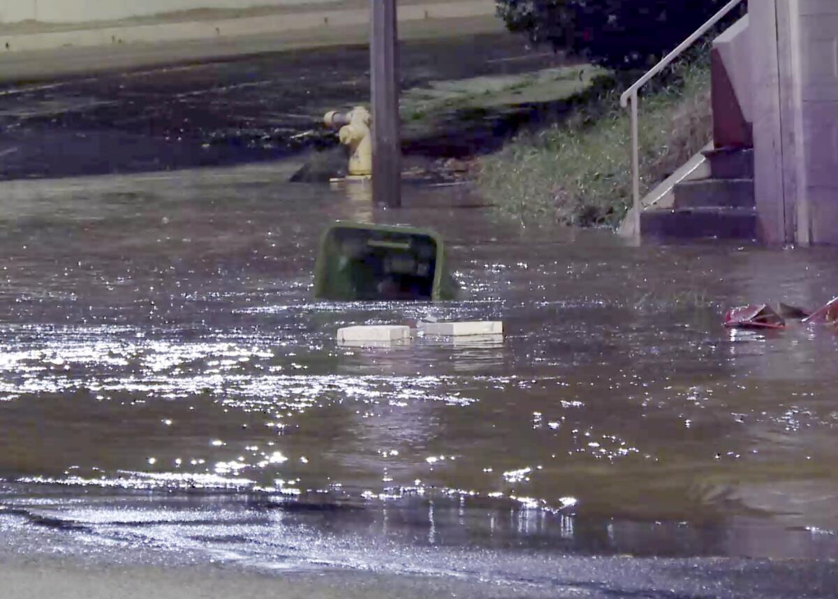 Debris floats as water floods a street.