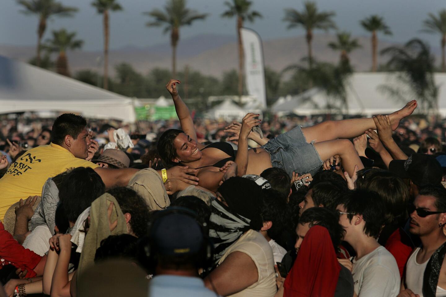 A fan is pulled from the crowd during the Arcade Fire performance, 2007.