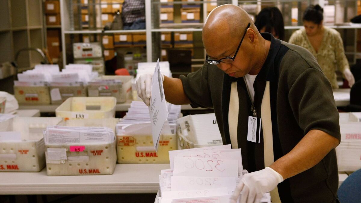 Absentee ballots are sorted in San Francisco in 2008. State law requires voters be allowed to mail in ballots, but the mandate was suspended when the state cut funding.